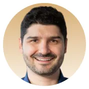 Portrait de Loïc, homme souriant aux cheveux bruns et barbe courte, en tenue professionnelle sur fond clair